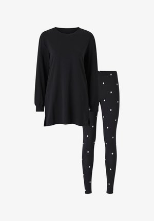 Schwarzes Langarmoberteil mit Seitenschlitzen, kombiniert mit schwarzen Leggings, die ein weißes Sternenmuster aufweisen. Weiches Material, lockerer Schnitt, einfaches Design.