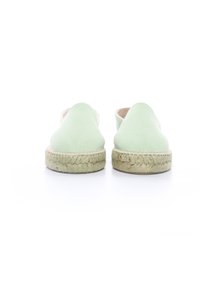 Espadrilles vert clair avec une tige en tissu doux et des semelles en jute tissées, présentant une texture lisse et un design minimaliste.