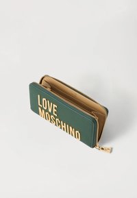 Zelená kožená peněženka se zlatým textem "LOVE MOSCHINO", se zipovým uzávěrem, béžovým interiérem a hladkým povrchem.