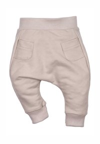 Lichte beige baby joggers met een geribbelde tailleband, twee voorzakken en taps toelopende pijpen, gemaakt van zachte katoen.
