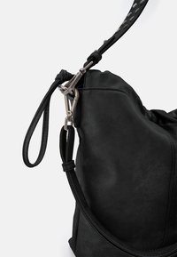 Borsa nera in pelle con superficie testurizzata, dotata di tracolla removibile e chiusura metallica. Forma curva con cuciture sottili.