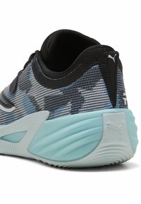 Gros plan d'une chaussure de sport bleue et noire avec une tige en mesh texturé et une semelle coussinée bleu clair montrant le talon et le logo Puma.