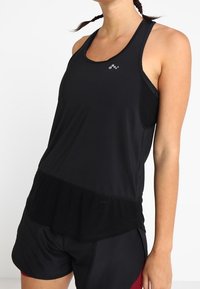 Czarny sportowy tank top o dopasowanym fasonie, ze stylem racerback i ząbkowanym dołem. Na klatce piersiowej znajduje się subtelne logo.