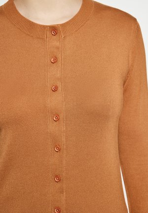 Braune gerippte Strickjacke mit rundem Ausschnitt, die sechs passende Knöpfe an der Vorderseite hat. Weiche Textur und taillierter Schnitt.