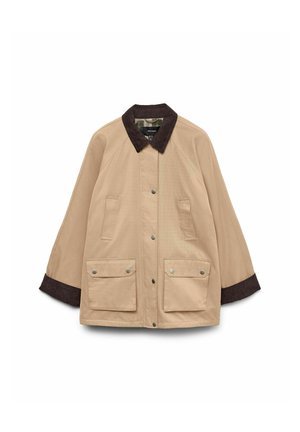 Smeđa jakna s okovratnikom od kordura, dva velika prednja džepa i kopčom na dugme. Ima opušteni kroj i duge rukave.