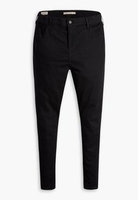 Jeans de mezclilla negra con corte ajustado, con cierre de botón, cinco bolsillos y una textura suave. Sin patrones ni acentos visibles.