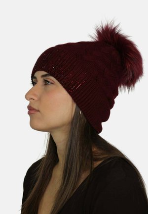 Berretto a maglia color marrone con motivo a treccia, dettagli scintillanti e pon pon in ecopelliccia sulla cima. Tessuto morbido, stile aderente.