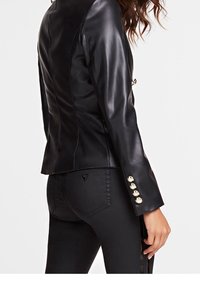 Czarna skórzana kurtka o dopasowanym kroju, z ozdobnymi złotymi guzikami na rękawach i gładką, błyszczącą fakturą.