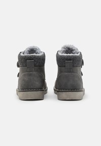 Graue High-Top-Schuhe mit einer strukturierten Oberseite, einem Filzkragen und einem weichen Futter. Mit einer Naht entlang der Sohle und einem Riemen für einen sicherenverschluss.