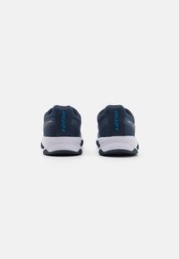 Sapatos de desporto azuis com parte superior em malha, solas brancas e um destacado logótipo "LOTTO". Apresentam um design texturizado e um calcanhar almofadado para suporte.