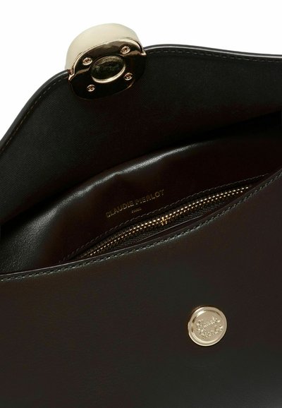 Borsa a mano in pelle nera con hardware dorato, dotata di tasca interna con zip e logo impresso. Texture liscia e forma strutturata.