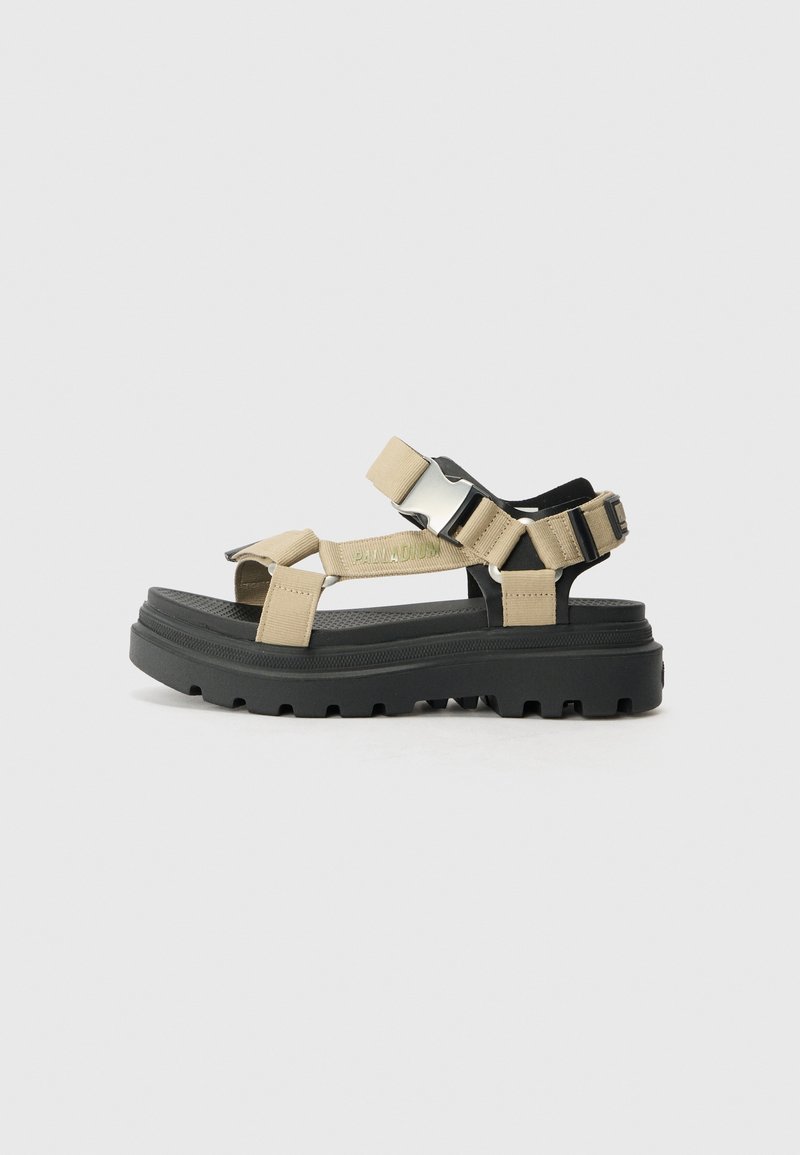 Beige sandalen met verstelbare banden en een dikke zwarte zool. Beschikt over een textuur voetbed en zilveren hardware accenten. Geeft een sportieve uitstraling.