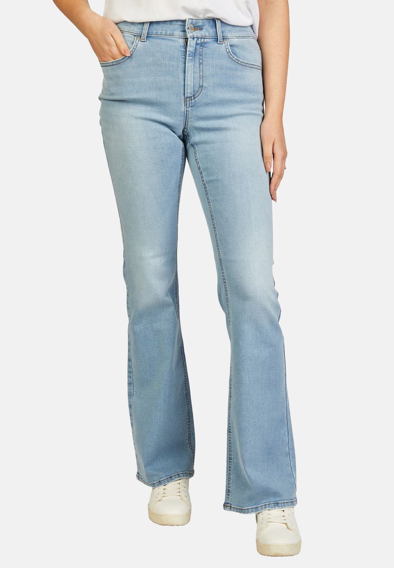 Lichtblauwe flared jeans van denim, met een hoge taille, voorzakken en een subtiele vervaging, gecombineerd met witte sneakers.