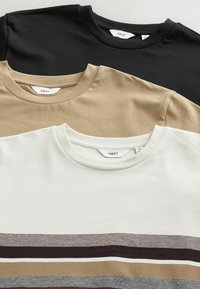 Kolme t-paitaa pinottuna: musta (ylhäällä), beige (keskellä) ja valkoinen, jossa on vaakaraitoja ruskeana ja harmaana (alhaalla). Puuvillamateriaali, pyöreä kaula-aukko.