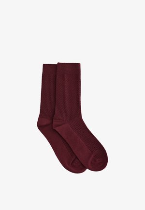 Calzini color bordeaux con motivo a trama e sezione inferiore liscia. Progettati con polsino a coste per una vestibilità sicura. Realizzati in materiale morbido.