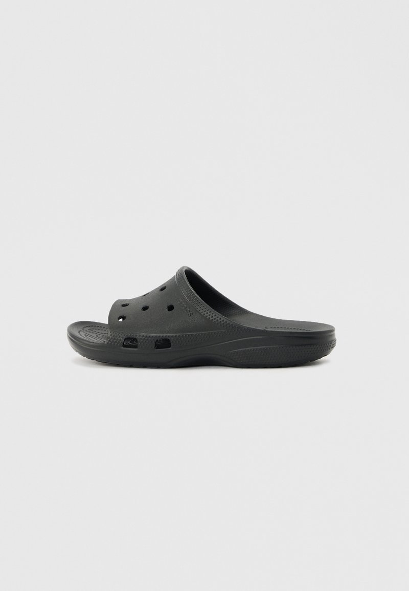 Sabot noir à enfiler avec perforations sur le dessus et les côtés, semelle intérieure texturée et semelle incurvée, conçu pour un port décontracté.