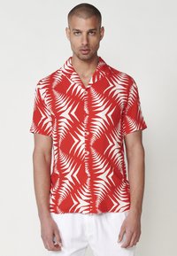 Rotes Kurzarmhemd mit einem weißen Farnblattmuster, aus leichtem Stoff gefertigt, mit Knopfleiste und einem klassischen Kragen-Design.