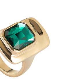 Bague en or avec une grande pierre précieuse émeraude taillée en carré, facettée avec une finition brillante, montée sur un anneau lisse et courbé.