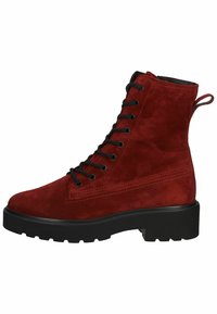 Bottines en daim rouge avec un devant à lacets noir, finition texturée et semelle épaisse noire. Présente une languette à l'arrière.
