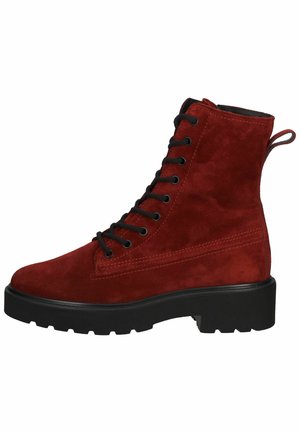 Botín de ante rojo hasta el tobillo con parte delantera de cordones negra, acabado texturizado y suela gruesa negra. Cuenta con una pestaña en la parte posterior.