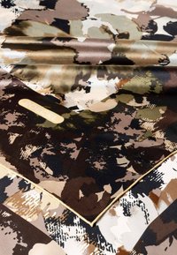 Seidenschal mit Camouflage-Muster in Brauntönen, Grüntönen und Schwarz. Die Ränder sind mit einem goldenen Akzent genäht und mit dem "Roeckl"-Logo versehen.