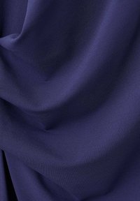 Granatowy, teksturowany materiał o miękkim opadaniu, ukazujący gładką, równą powierzchnię z delikatnym połyskiem. Idealny do odzieży lub tapicerki.