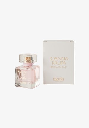 Przezroczysta butelka perfum o kwadratowym kształcie, z jasno różowym płynem i złotymi akcentami. Zawiera białe pudełko ze złotym napisem.