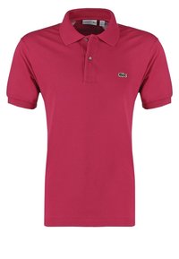 Polo rouge à manches courtes avec patte à deux boutons et petit logo crocodile vert sur la poitrine gauche.