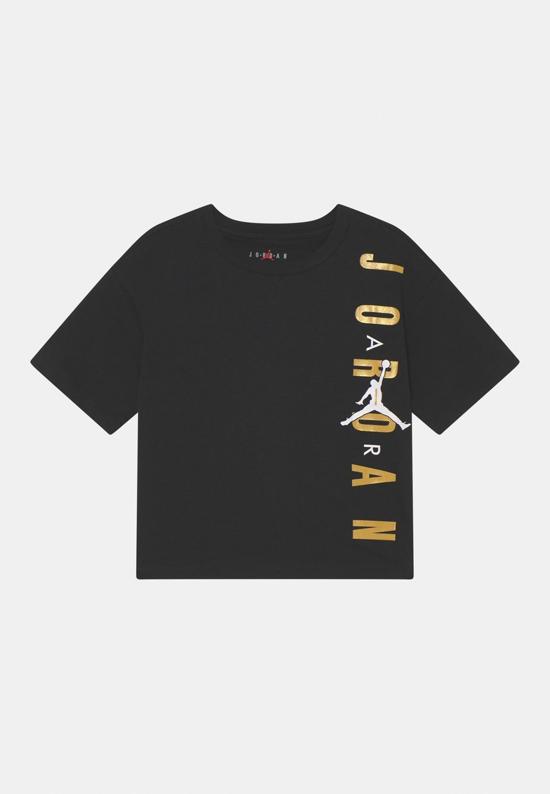Crop top noir à manches courtes avec texte vertical doré "JORDAN" et logo Jumpman blanc sur le côté droit.