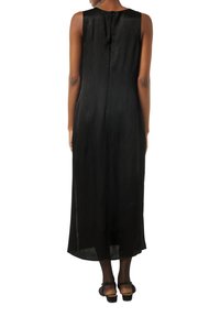 Czarna bezrękawnikowa sukienka maxi z teksturowanej tkaniny, prosta sylwetka i zamek błyskawiczny z tyłu. Dół sukienki sięga poniżej łydki.