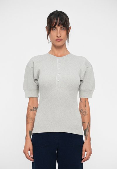 Top grigio a righe con maniche corte e scollo rotondo, caratterizzato da cinque bottoni sul davanti e maniche a sbuffo per un volume aggiuntivo.