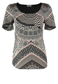 T-shirt à manches courtes pour femmes avec des motifs géométriques et en zigzag noirs, blancs et roses, et un col rond.