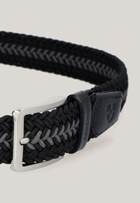 Czarny i szary pleciony pasek z metalową klamrą w kolorze srebrnym. Posiada skórzany akcent z wytłoczonym logo. Teksturowana powierzchnia.