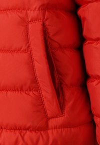 Giacca imbottita rossa con texture liscia, design trapuntato e tasca laterale con apertura dritta.
