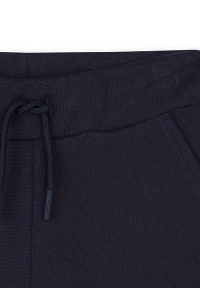 Pantalon de survêtement bleu marine avec une texture douce, ceinture élastique et cordon de serrage. Comprend des poches latérales pour plus de commodité.