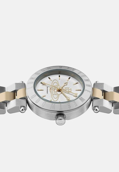 Ronde zilverkleurige horloge met een witte gestructureerde wijzerplaat, gouden accenten en een roestvrijstalen band met een gouden schakelontwerp.