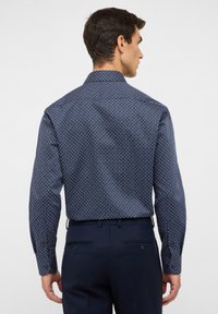 Navyblaues Hemd mit einem kleinen weißen Blumenmuster, langen Ärmeln und Knopfmanschetten; glattes Material mit taillierter Passform.