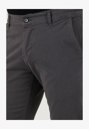 Donkergrijze katoenen broeken met een ritssluiting en knoopsluiting, voorzien van zijzakken en een gladde textuur.