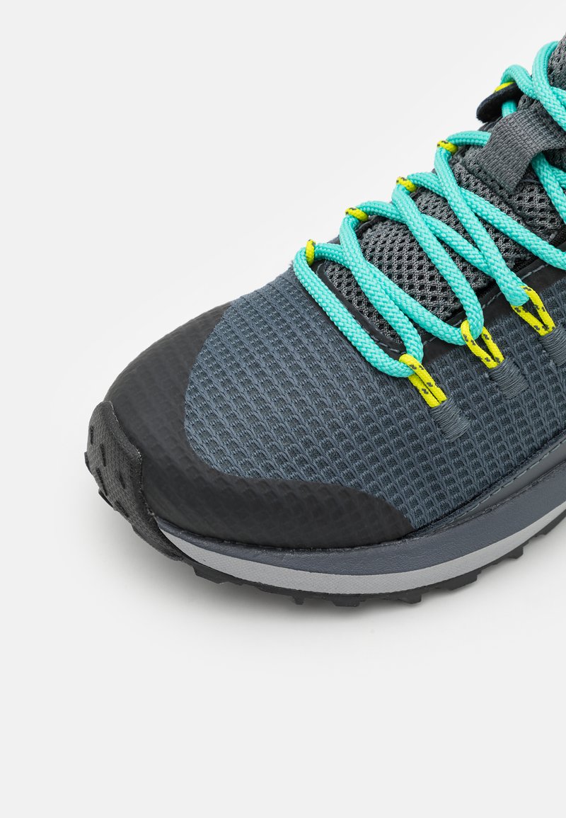 Szare buty sportowe z przewiewną siateczką, turkusowymi sznurówkami i czarną gumową podeszwą z fakturowanym gripem. Żółte akcenty na oczkach do sznurówek.