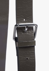 Cinturón de cuero sintético gris con una superficie texturizada, que presenta una hebilla metálica plateada y agujeros para ajuste a lo largo de la longitud de la correa.