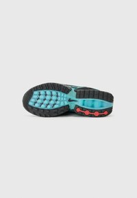 Sole di scarpa sportiva nera con intersuola turchese, caratterizzata da accenti rossi e da un motivo testurizzato per una migliore aderenza.