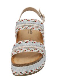 Sandały na paski z plecionymi akcentami w kolorze srebrnym, czerwonym i zielonym, z wyściełaną beżową wkładką i zapięciem na klamrę na jasnej podeszwie.