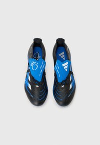 Schwarze und blaue Sportschuhe mit einem schlanken Design, ausgestattet mit einer leuchtend blauen Zunge und markanten Details, aus der Vogelperspektive gezeigt.