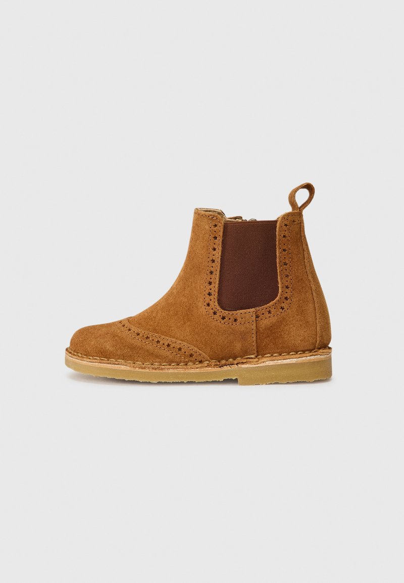 Brune mockaskinn ankelboot med elastiske sidepaneler, perforerte detaljer og en drakehank. Flat såle med en kontrasterende, lett base.