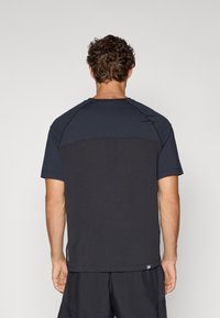 Dark gray athletic t-shirt featuring a contrasting solid black panel across the upper back, with short sleeves and a rounded neckline.