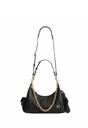 Sac à main en cuir noir matelassé avec détail chaîne dorée, bandoulière réglable, poches latérales et petite étiquette en cuir attachée.