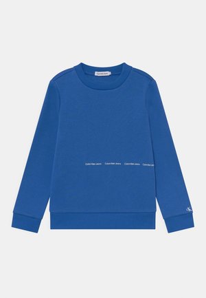 Niebieska bluza z długim rękawem, z prążkowanym kołnierzem, mankietami i dołem, z małym napisem „Calvin Klein Jeans” na środku i na mankiecie rękawa.