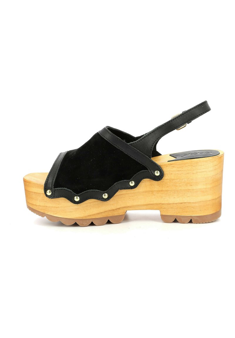 Sandali platform in suede nero con bordo scalloppato, base in legno e borchie metalliche. Cinturino regolabile sul retro per una vestibilità sicura.