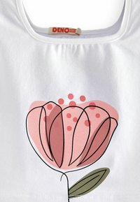 Witte katoenen tanktop met een roze bloemenpatroon met zwarte omlijningen, groene bladeren accenten en kleine roze stippen boven de bloem.