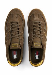 Braune Wildleder-Sneaker mit Mesh-Details, runden Schnürsenkeln und gelben Akzenten. Verfügt über eine strukturierte Sohle und "Tommy Jeans"-Markierung im Inneren.